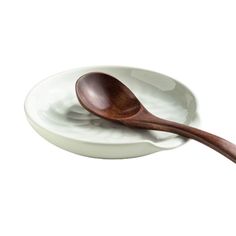 a wooden spoon sitting on top of a white plate