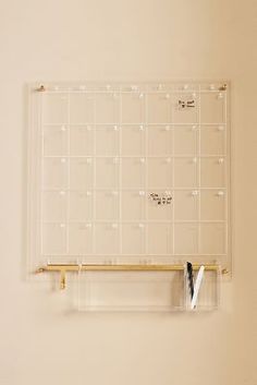 a wall mounted calendar on the side of a white wall next to a pair of scissors