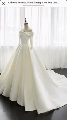 a white wedding dress on display in front of a window