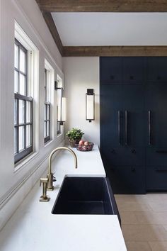 a kitchen with white counter tops and black cabinets