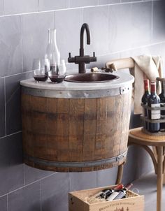 a wooden barrel sink in a bathroom next to a wine glass holder and bottle opener