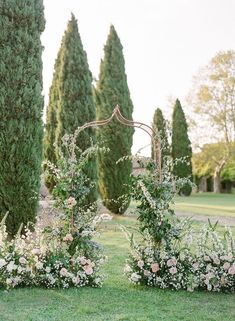 the bride and groom are standing in front of their wedding arch with flowers on it