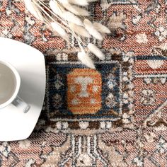 a coffee cup and saucer sitting on top of a rug