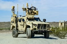 an army vehicle parked on the side of a dirt road