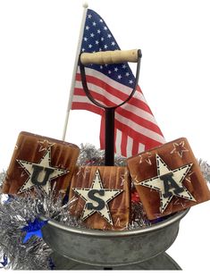 an american flag and some cookies are in a metal bowl with tinsel on it