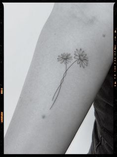 a single flower tattoo on the left arm