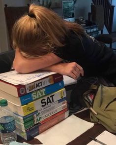 a woman is leaning her head on some books