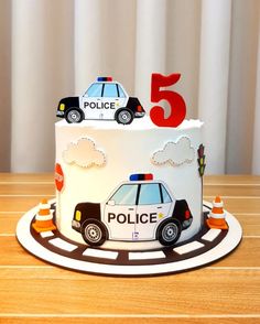 a birthday cake with a police car on top and the number five in the middle