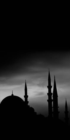 a black and white photo of an old building with spires in the dark sky