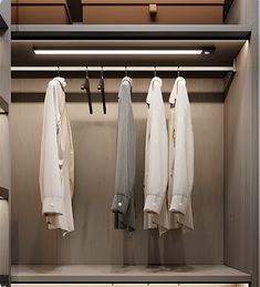 an open closet with clothes hanging on hooks