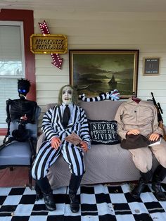 two creepy people sitting on a couch in front of a house with black and white checkered flooring