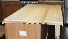 a kitchen island made out of plywood is shown in front of an oven and refrigerator