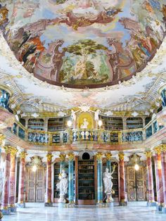 the interior of a library with paintings on the ceiling and columns in front of it