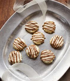 six cookies with icing on a silver plate