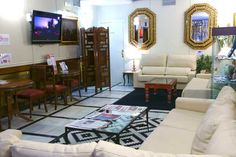 a living room filled with furniture and a flat screen tv mounted to the side of a wall