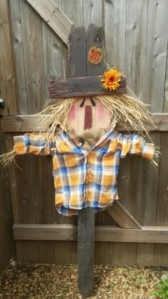 a scarecrow wearing a hat and plaid shirt