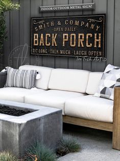 a white couch sitting on top of a cement block next to a wooden bench and potted plant