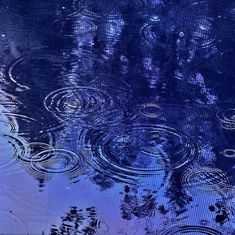 raindrops are reflected in the blue water