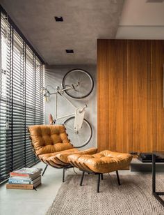 a living room with a bicycle mounted to the wall next to a chair and table