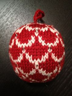 a red and white knitted ornament sitting on top of a table