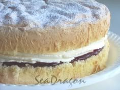 a cake sitting on top of a white plate covered in powdered sugar and jelly