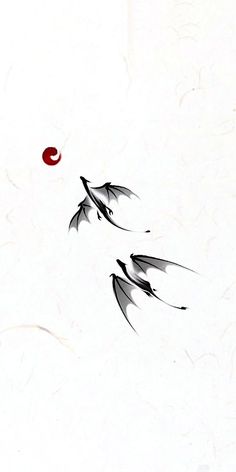 two black birds flying in the sky with a red ball