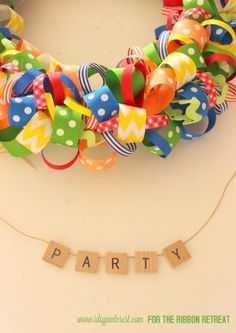 a colorful ribbon wreath with the word party spelled out in small letters on a string