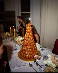 a table topped with lots of donuts covered in icing and surrounded by candles