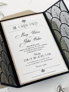 an elegant black and white wedding card with gold foiling on the inside is displayed