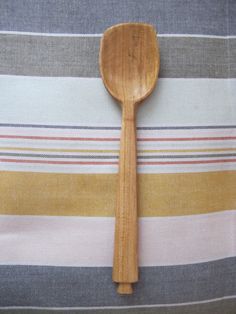 a wooden spoon sitting on top of a striped table cloth