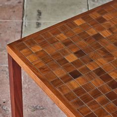 a close up of a wooden table with tile on the top and bottom surface,