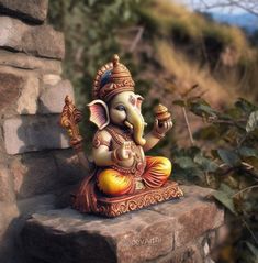 an elephant statue sitting on top of a stone wall