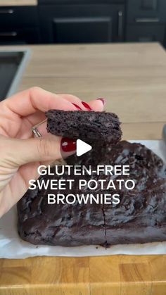 a person holding a piece of brownie in their hand with the words gluten - free sweet potato brownies