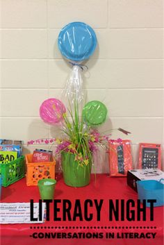 there is a table with balloons, books and other items on it that say literracy night