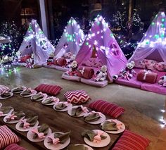 a room filled with lots of pink and white plates on top of a wooden table