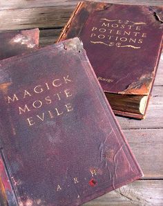 two old books sitting on top of a wooden table