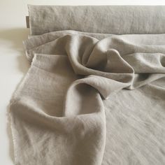 an unmade bed with linen on top of it