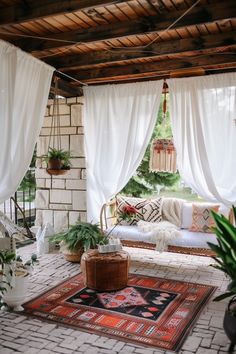 a living room with white drapes and rugs