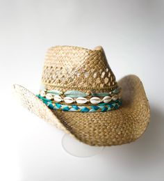 Did someone say coastal cowgirl summer??? Beach day? Country concert? Girls trip? Our handmade cowgirl hats are the PERFECT accessory for any outfit! The Kailani (or Sea & Sky) Hat is a tan straw cowgirl hat decorated with blue & gold ribbon, plain cowrie shells, & gold chain. Hawaiian Cowgirl, Coastal Cowgirl Hats Diy, Beachy Cowboy Hat, Coastal Cowgirl Hat Ideas, Straw Cowgirl Hats Beach, Coastal Cowgirl Hat, Coastal Cowgirl Beaded Hat, Cowgirl Party Outfit, Straw Cowgirl Hat