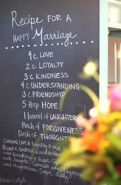 a chalkboard sign that says recipe for a happy marriage with flowers in the foreground