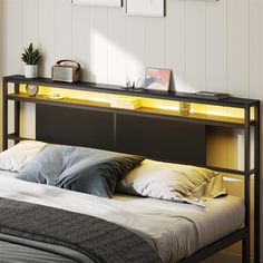 there is a bed with yellow lights on the headboard and night stands above it