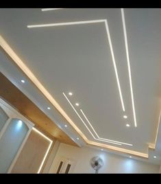 a room with some lights on the ceiling and white lighting above it is a mirror