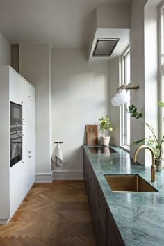 a kitchen with marble counter tops and wooden floors