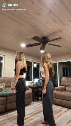 two women standing in front of a ceiling fan