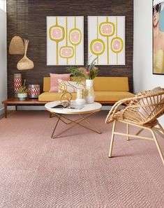 a living room with pink carpeting and art on the wall behind the couches