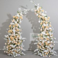 two white and yellow flowers are arranged in the shape of an arch