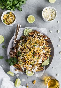 mexican street food served on a plate with limes, cilantro and rice