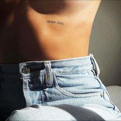 the back of a woman's stomach with a small tattoo on her left side