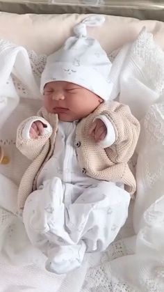 a baby in a white outfit is laying down