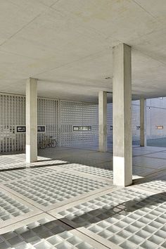 an empty parking garage filled with lots of cement blocks and concrete pillars, all covered in white tiles